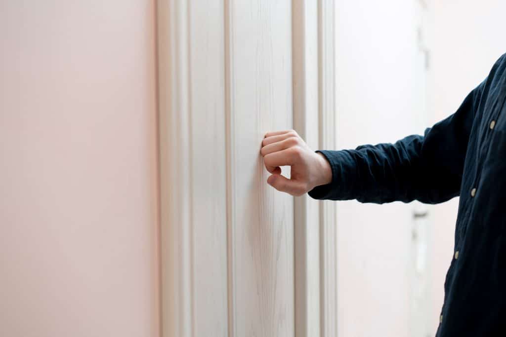 a person hand knock the door, visit the friends house