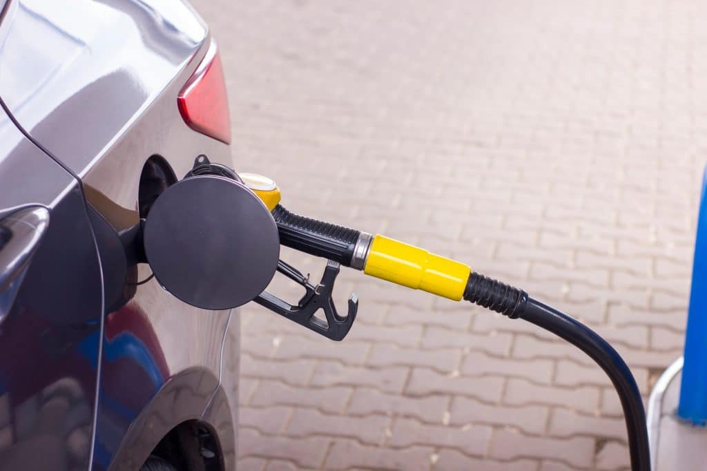 Closeup petrol pump filling fuel nozzle in fuel tank of car at gas station