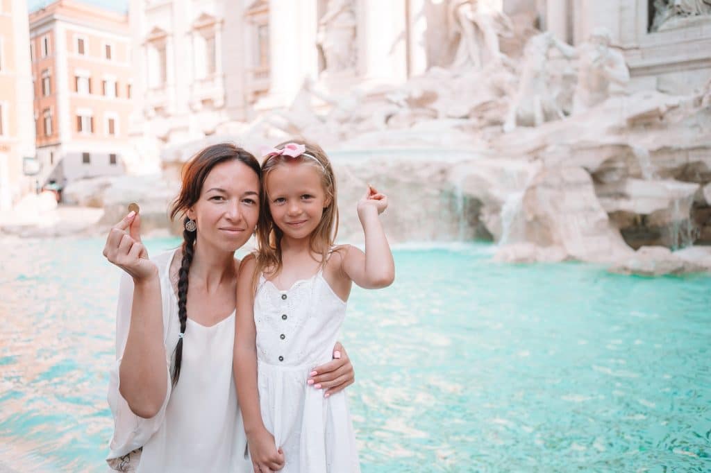 Young beautiful woman and little girl near fountain Fontana di Trevi