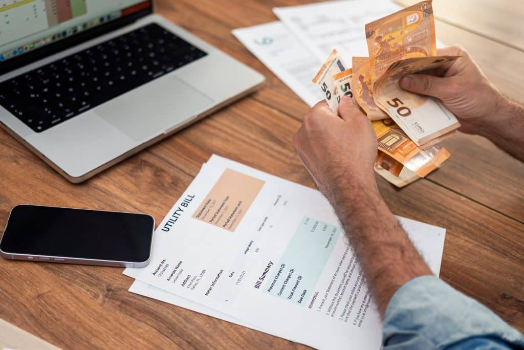 Mature businessman counts euros bills processing utility bills at office table household services
