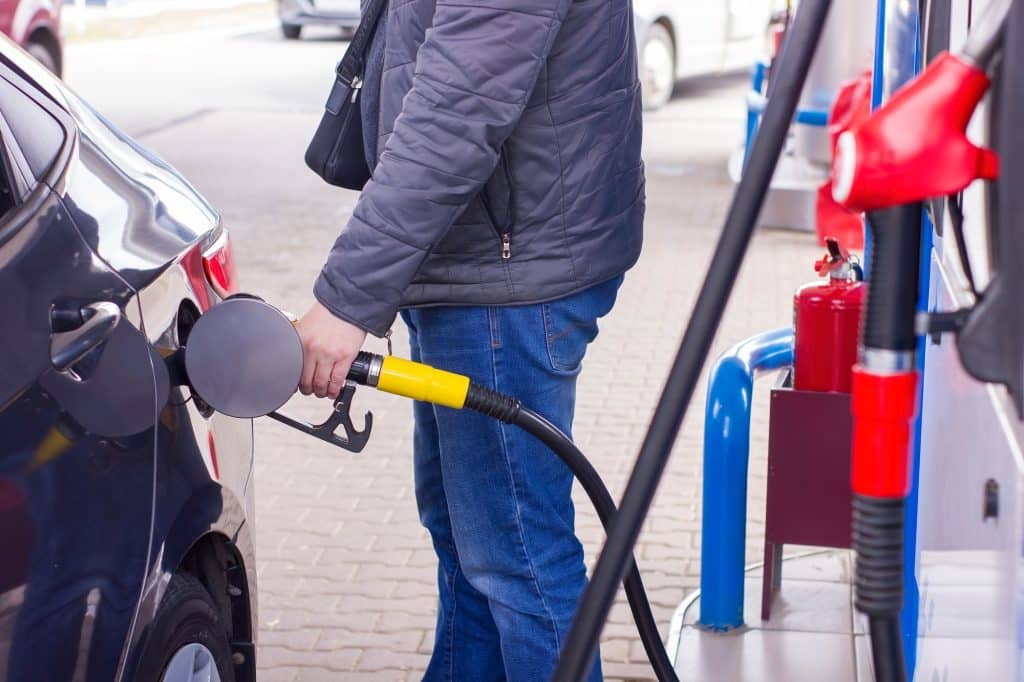 Man refuelling a car at a petrol station.