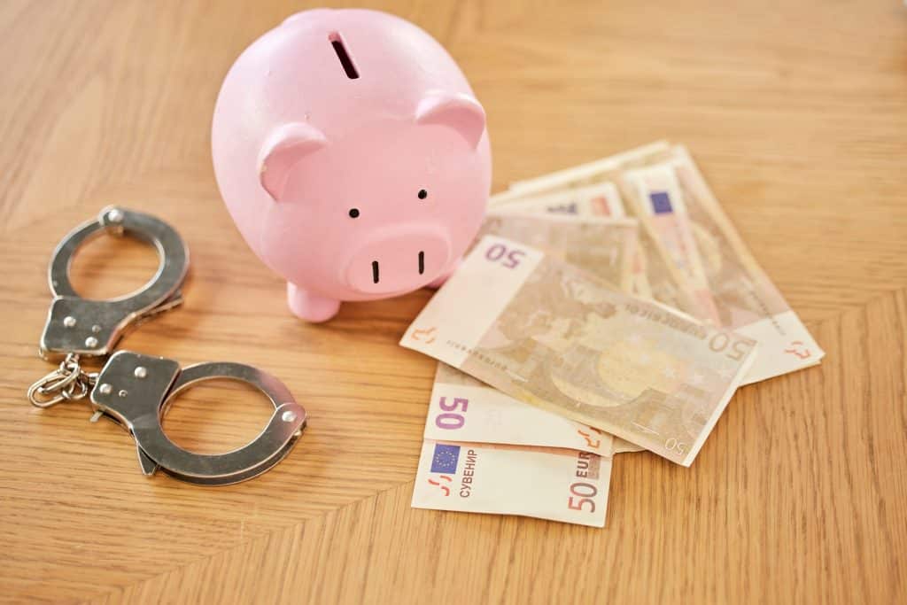 Piggy bank, money and handcuffs fraud crime for euro scam, corruption and criminal wealth exchange.