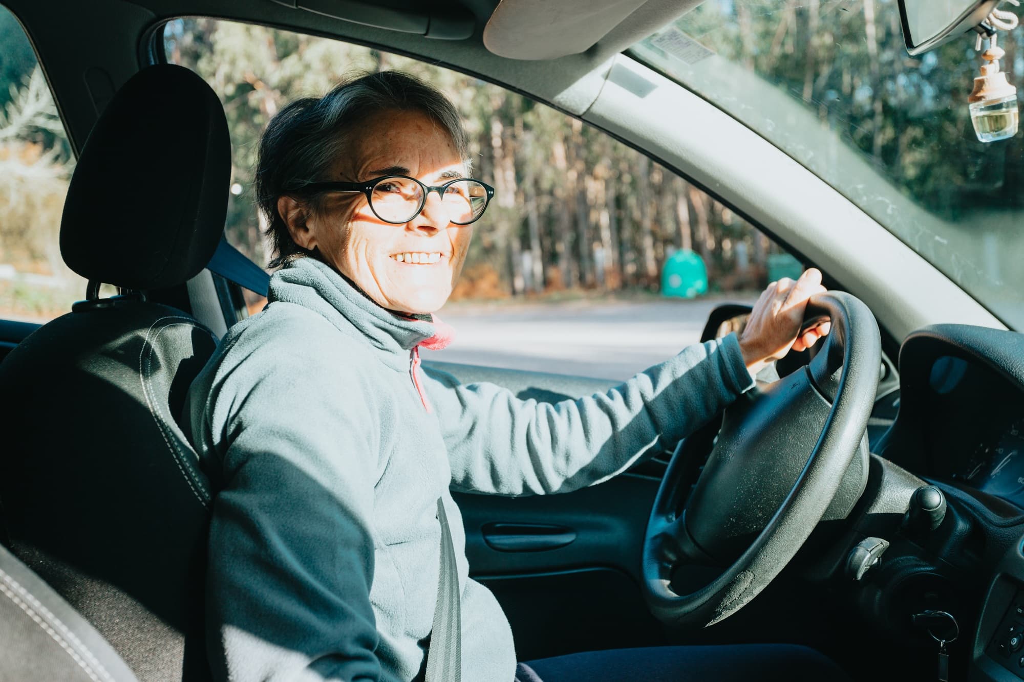 Portrait of a happy smiling senior woman learning to drive a car. Safety drive. Learning new hobby