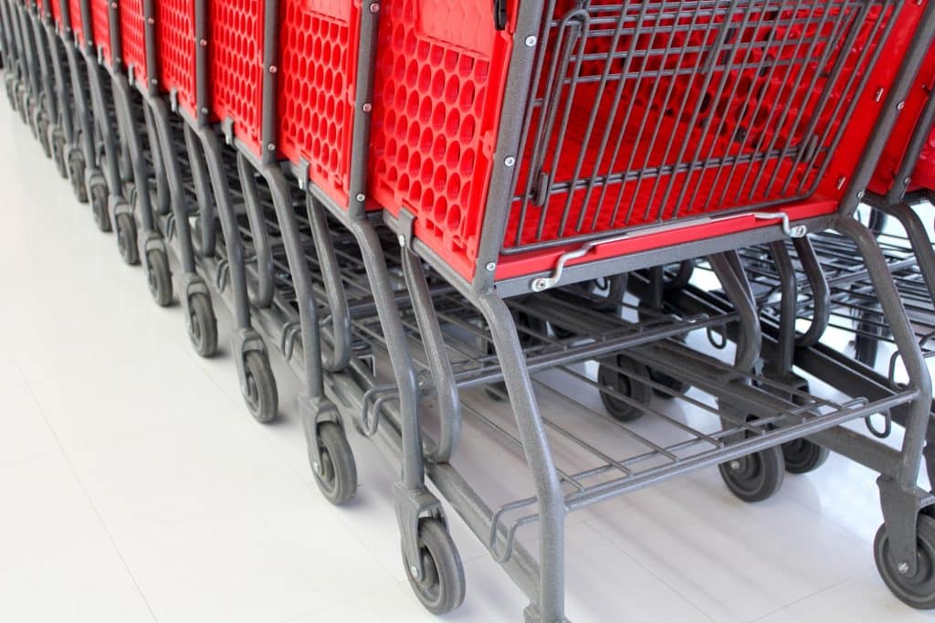Red shopping carts or buggies or trolleys lined up in a supermarket
