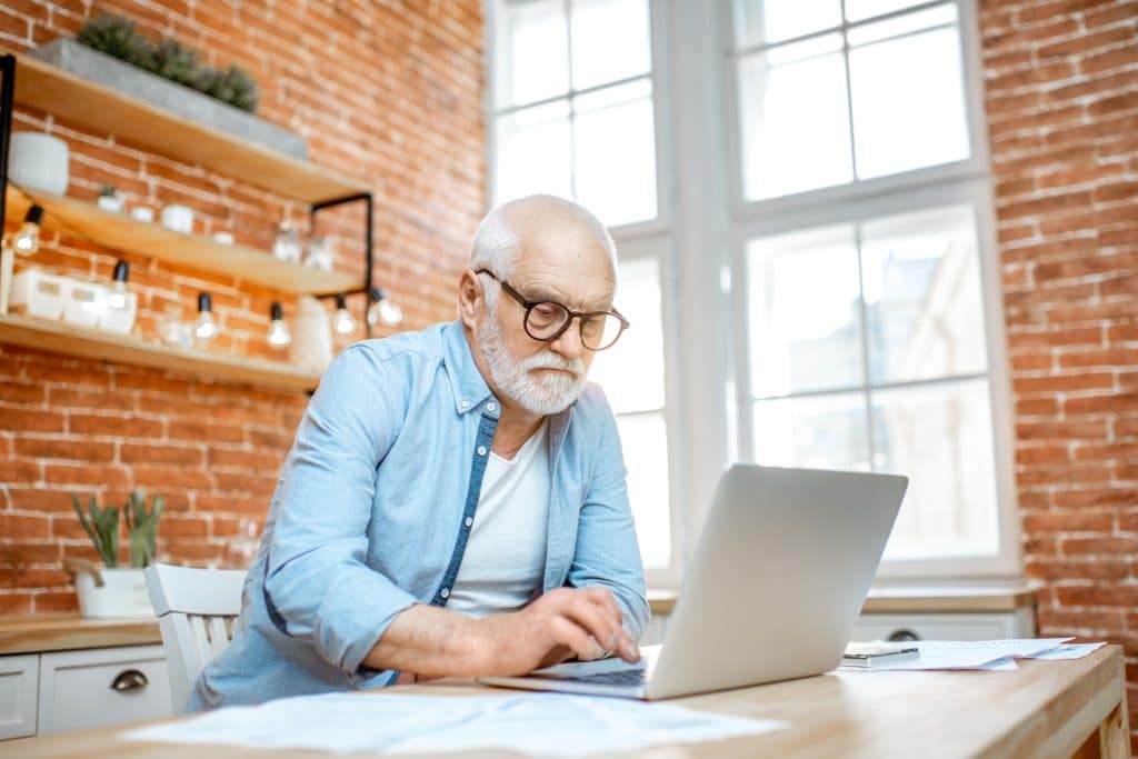 Senior man with laptop at home